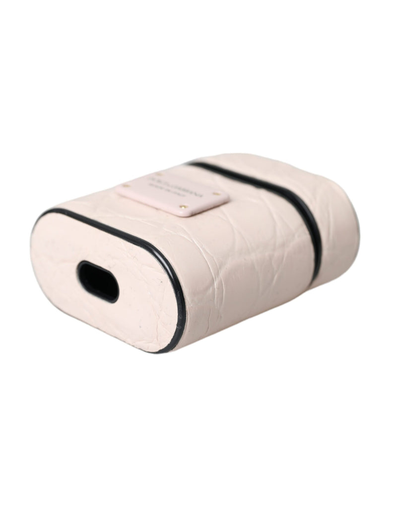 Light pink textured leather AirPods case with black trim and a metal logo plaque on top