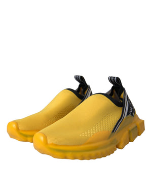 Bright yellow mesh slip-on sneakers by Dolce & Gabbana with black trim and chunky rubber soles.