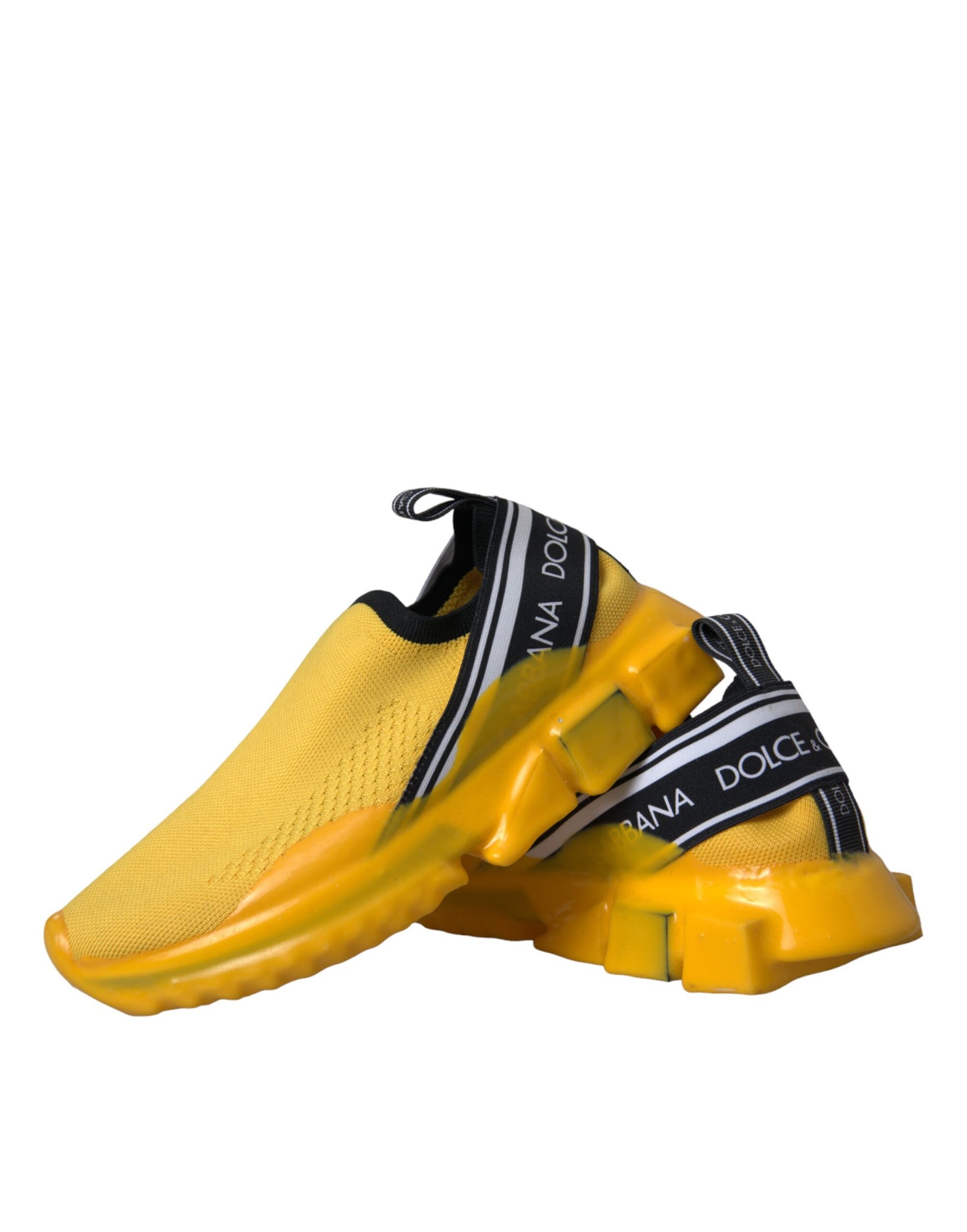 Yellow stretch knit slip-on sneakers with black logo-branded elastic bands and thick, sculpted yellow rubber soles.