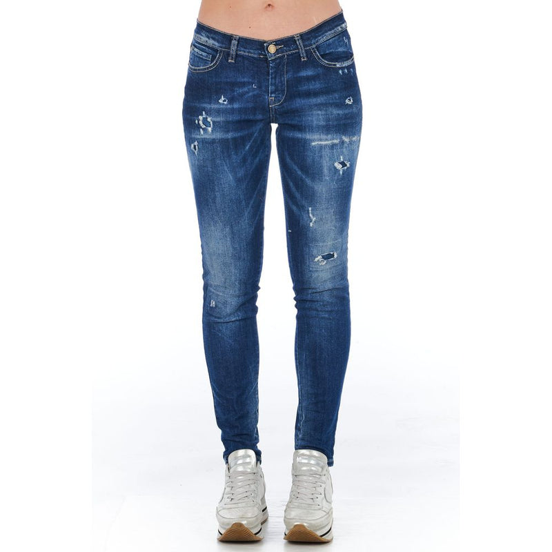 Blue cotton distressed skinny women jeans worn with silver sneakers