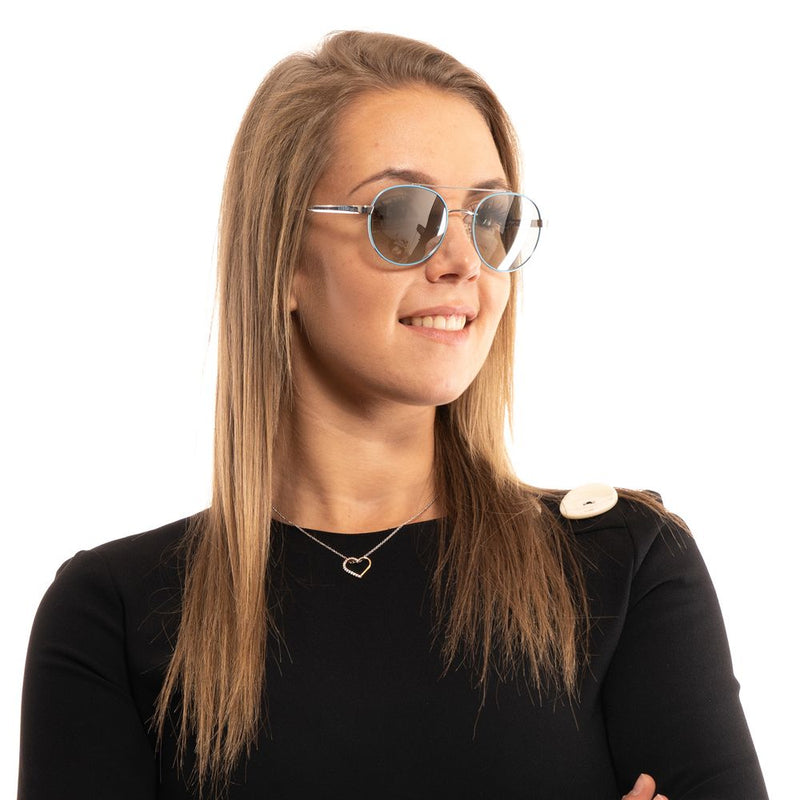 Guess turquoise metal sunglasses with round frames worn by a woman