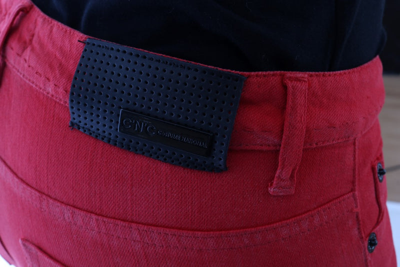 Red cotton stretch slim jeans with a black perforated leather brand patch on the back waistband