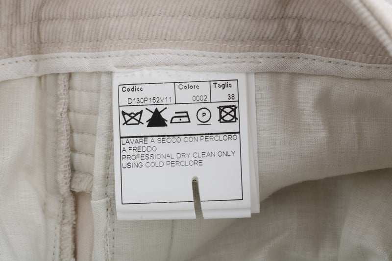 Beige corduroy skinny pants with brand tag showing care instructions