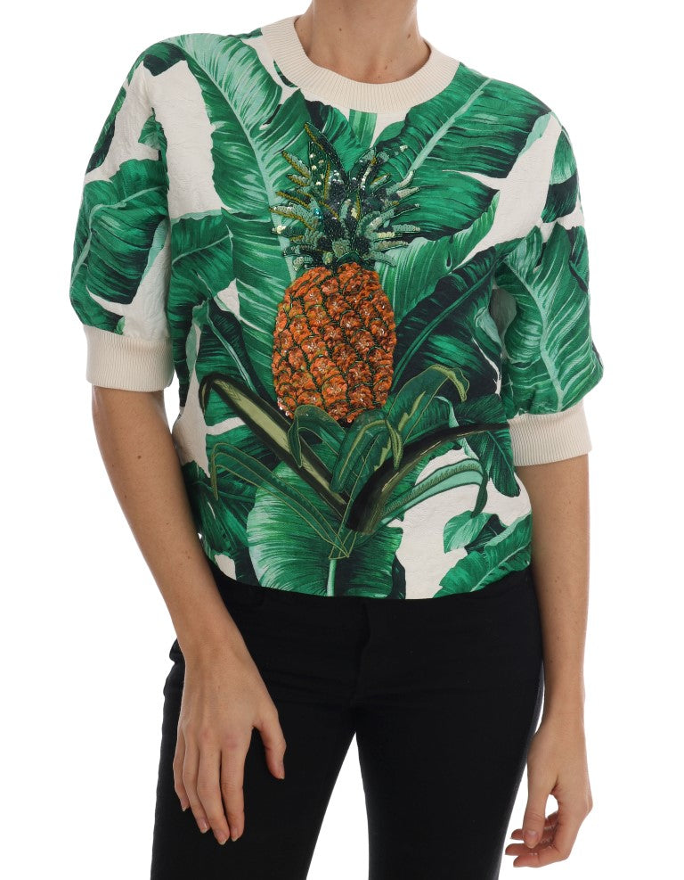 White short-sleeve crewneck sweater with green banana leaf print and beaded orange pineapple graphic