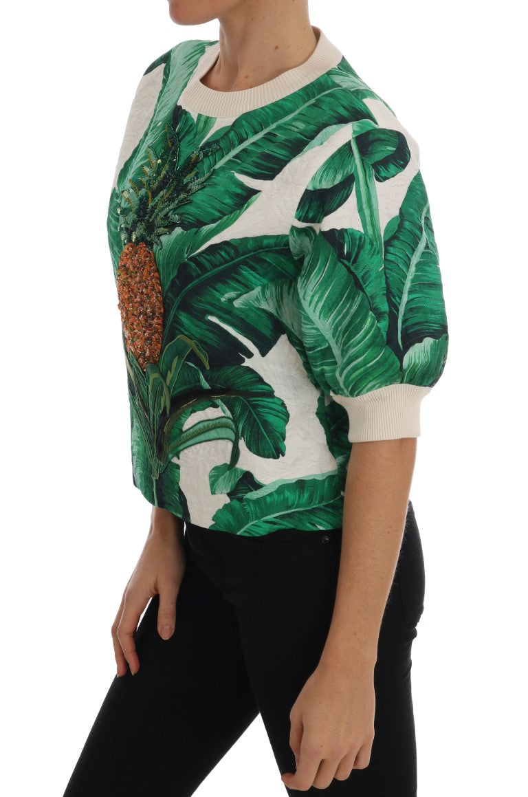 White crewneck sweater with green banana leaf print and beaded pineapple graphic on the front