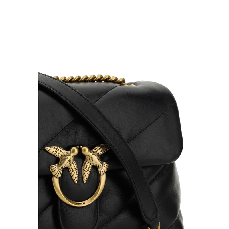 Black quilted leather shoulder bag featuring a gold bird clasp and chain strap