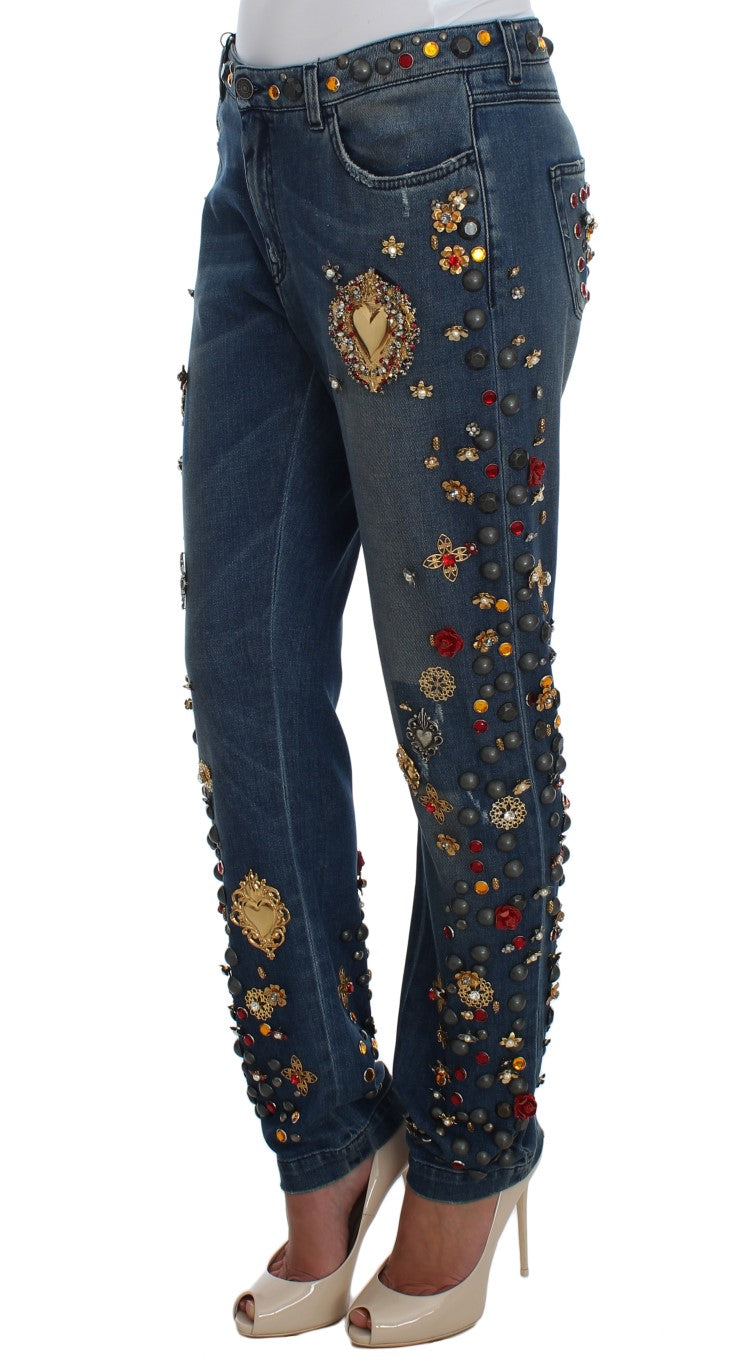 Blue denim jeans heavily embellished with colorful crystals, metal studs, and gold heart appliqués