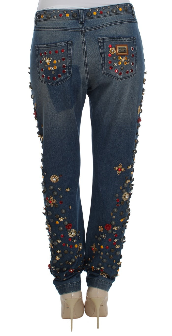 Blue denim jeans with crystal, rose, and bead embellishments on the back pockets and legs