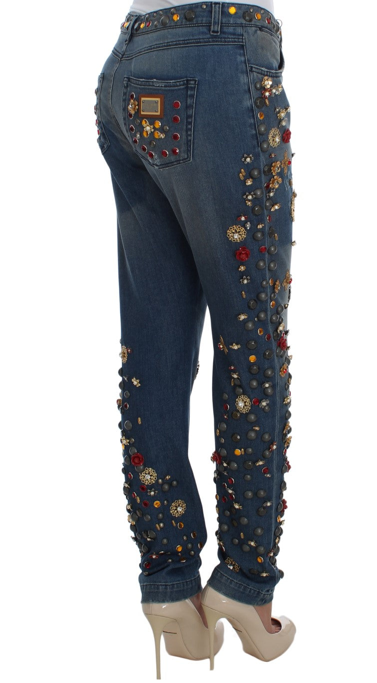 Blue denim jeans with crystal roses and embellished studs worn from behind