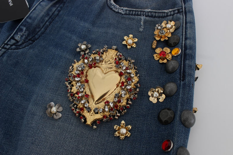 Blue denim jeans embellished with a large gold heart surrounded by crystal and red stones and gold floral accents