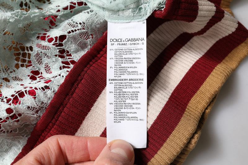 A hand holds the label inside a multicolor floral lace cardigan sweater with striped ribbed trim
