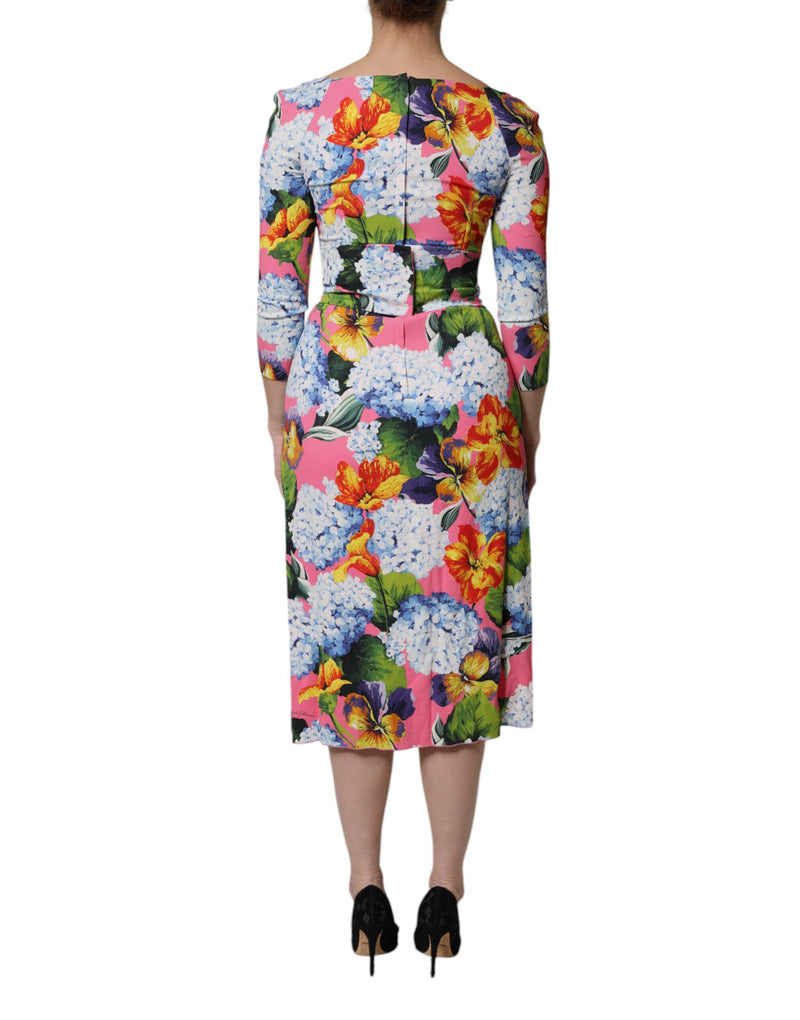 Back view of a pink multicolored floral midi dress with sleeves worn with black heels