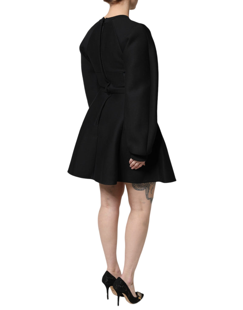 Black cotton long-sleeve A-line mini dress with a fitted waist and flared skirt worn by a model