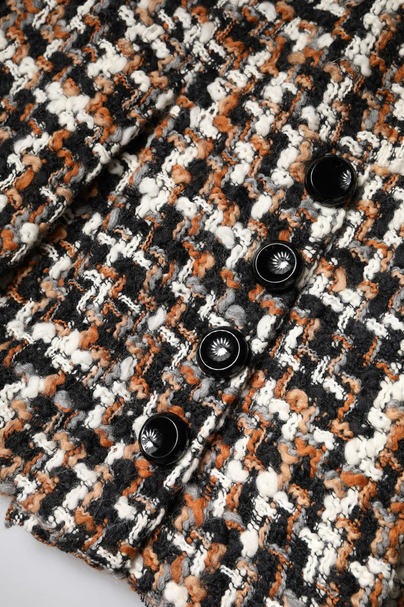 Close-up of multicolor tartan tweed mini skirt with four shiny black round buttons