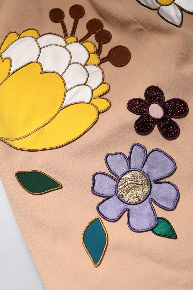 Beige pencil skirt with large embroidered floral appliqués in yellow, purple, and brown