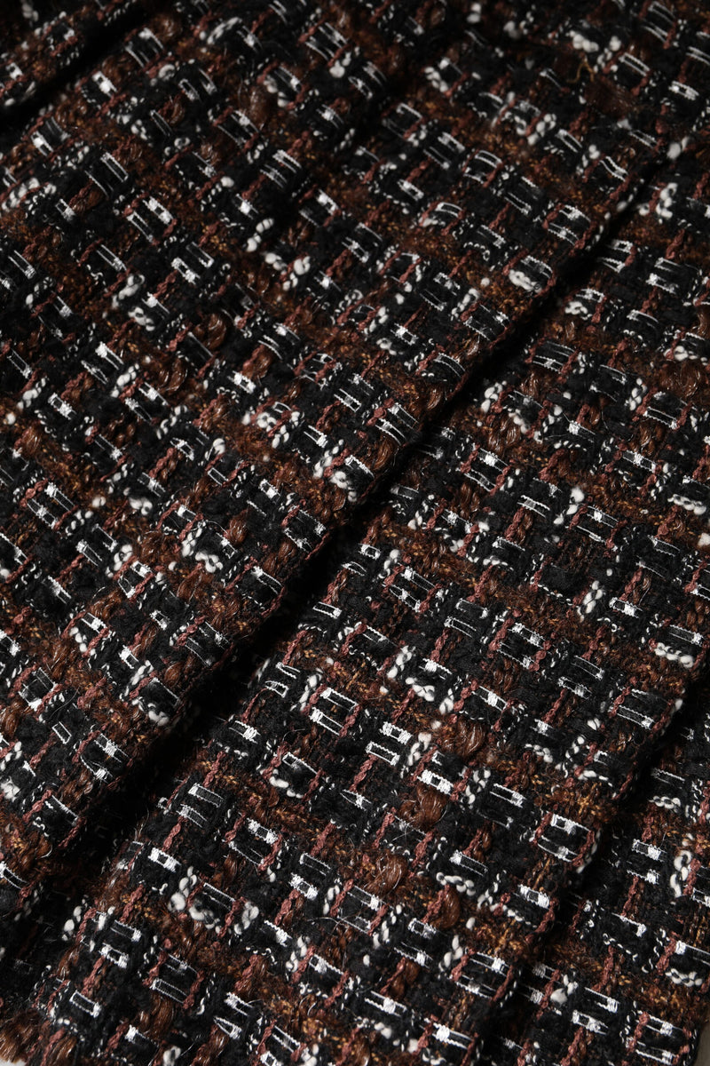 Close up of black, brown and white tweed fabric featuring a textured checkered pattern