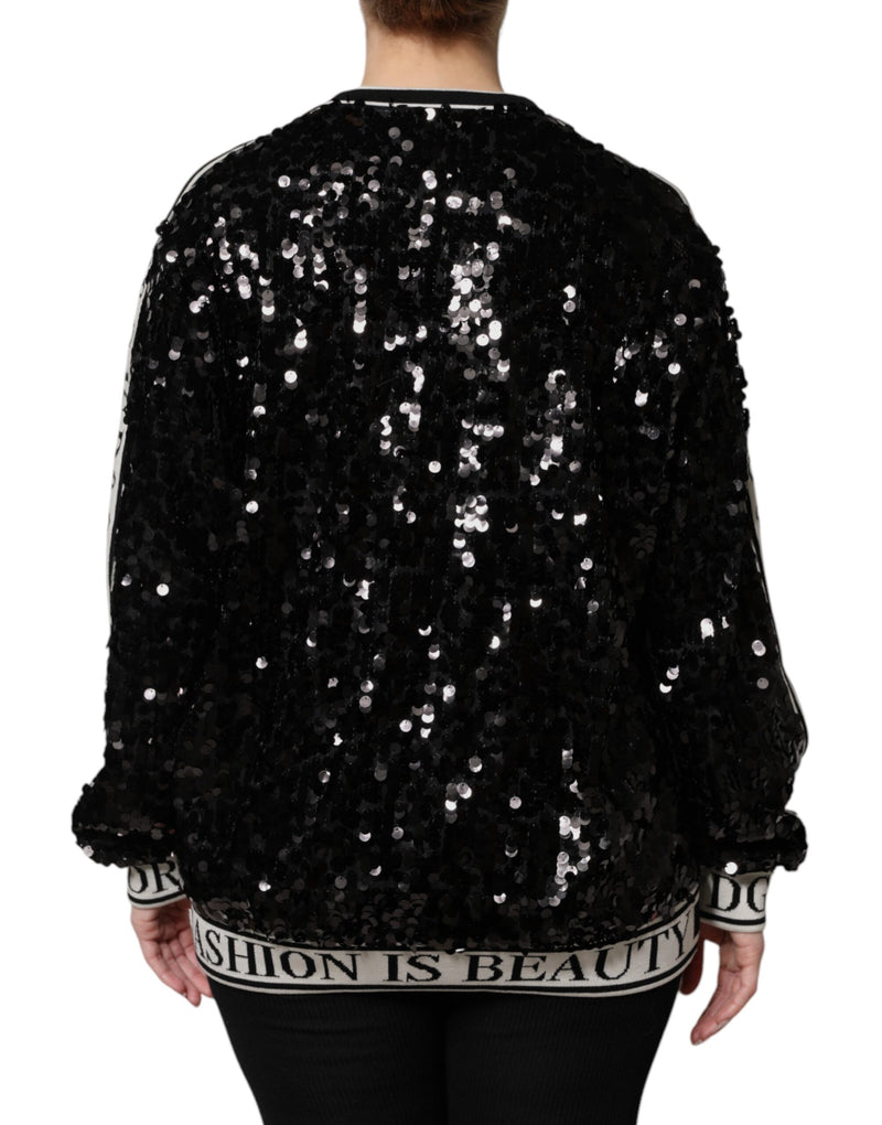 Black sequin pullover sweater with white-striped ribbed hem and cuffs featuring text