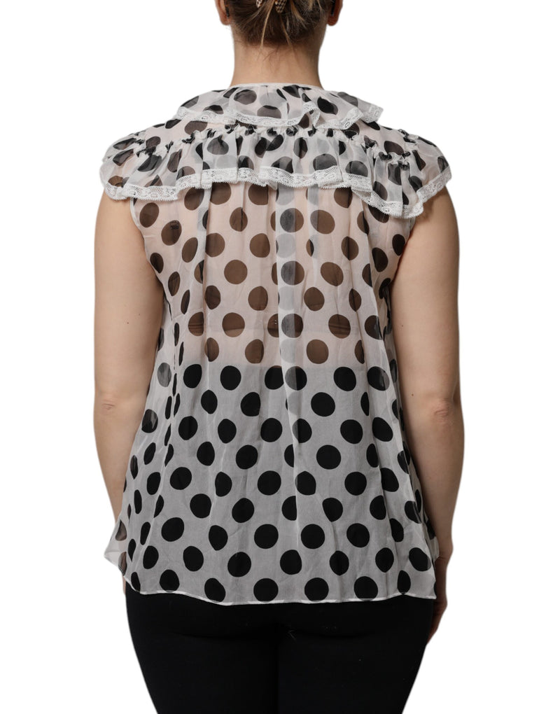 White and black polka dot sleeveless cotton top with ruffled neckline and lace trim worn from the back