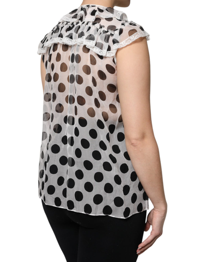 White sleeveless top with black polka dots, sheer fabric, ruffled collar and lace trim