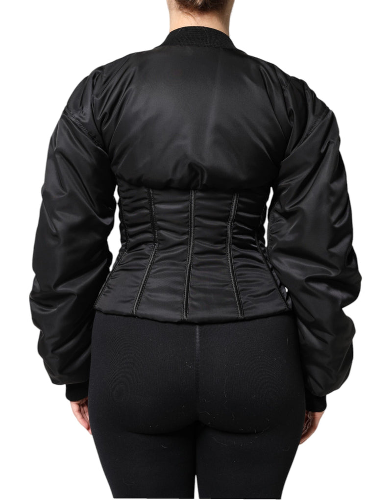 Black nylon corset jacket with long sleeves and boning detail, viewed from the back