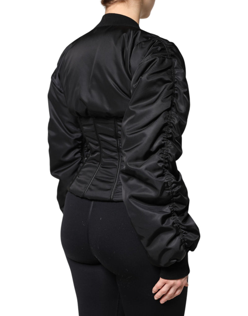 Black nylon corset jacket with cinched waist and ruched long sleeves viewed from the back