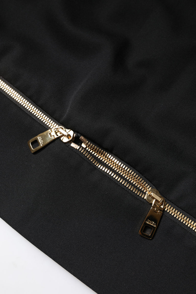Close-up of a black wool mini skirt featuring a two-way gold zipper