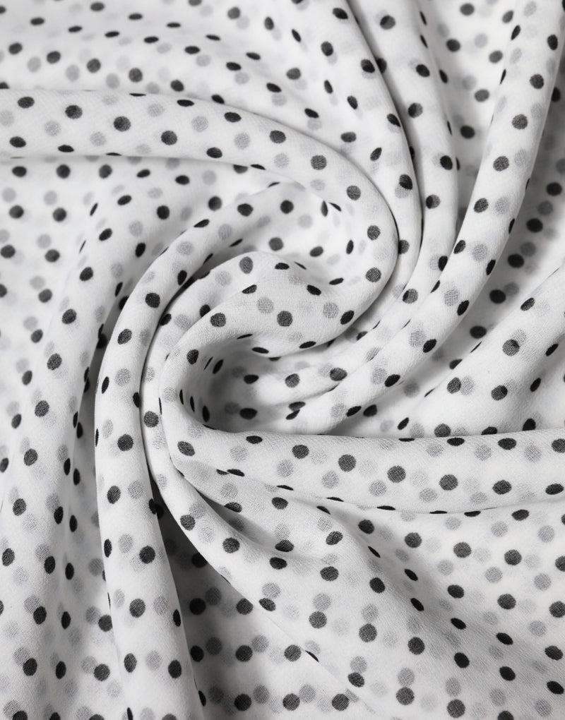 White polyester wrap scarf with black polka dots draped in folds