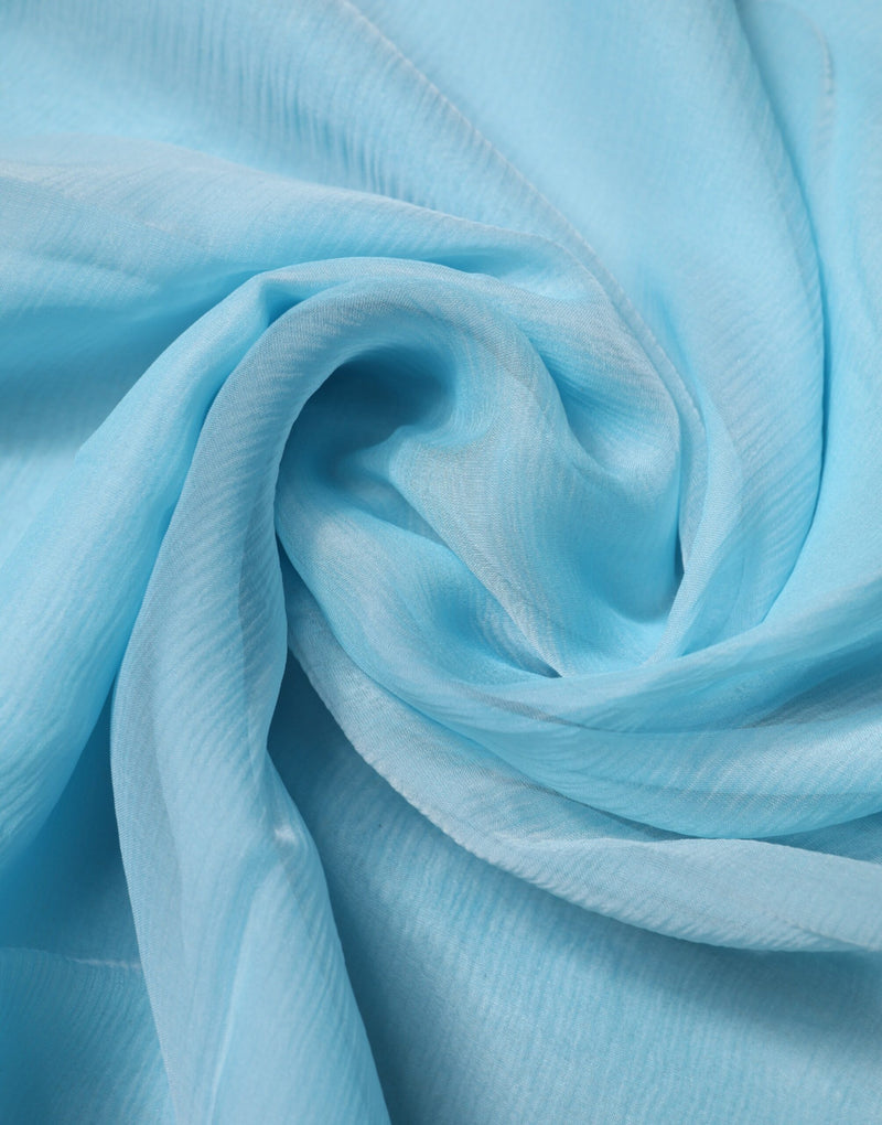 Light blue silk wrap scarf gathered in a soft swirl texture