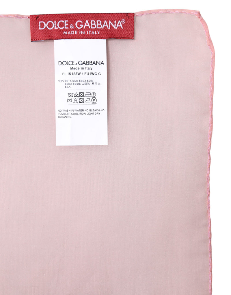Close-up of a pink silk wrap scarf with a Dolce and Gabbana brand label and care tag