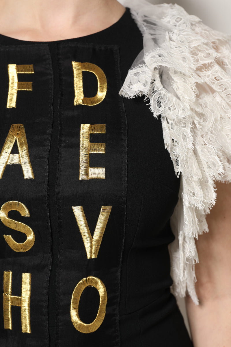 Black mini dress with gold embroidered letters and white lace sleeves
