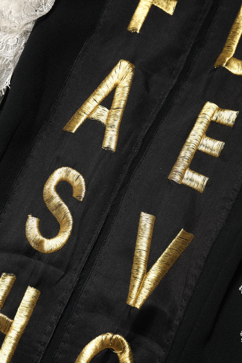 Black mini dress with gold embroidered lettering and white lace trim