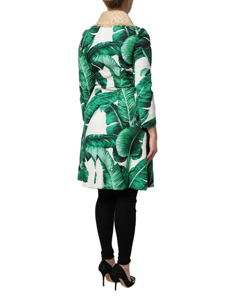 Back view of a white trench coat with a green banana leaf print and straw collar worn with black leggings