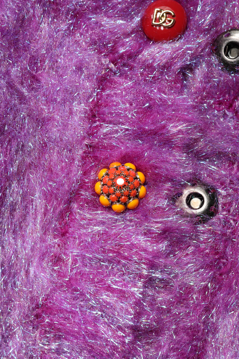 Close up of a purple shaggy textured coat with ornate jewel buttons