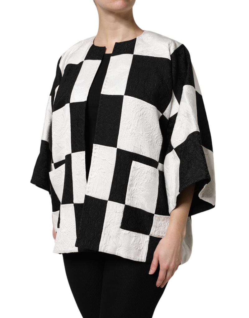 Black and white patchwork jacquard jacket with an open front and short sleeves worn over black clothing