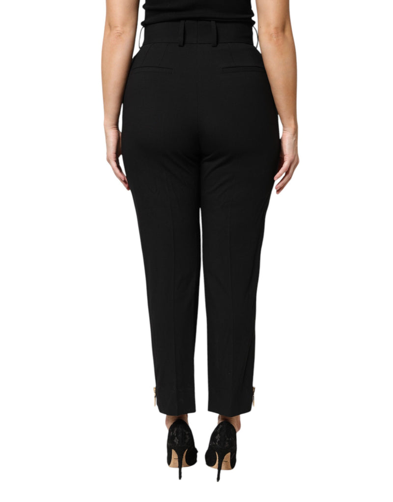 Black wool high-waist tapered pants with ankle zippers on a person seen from behind