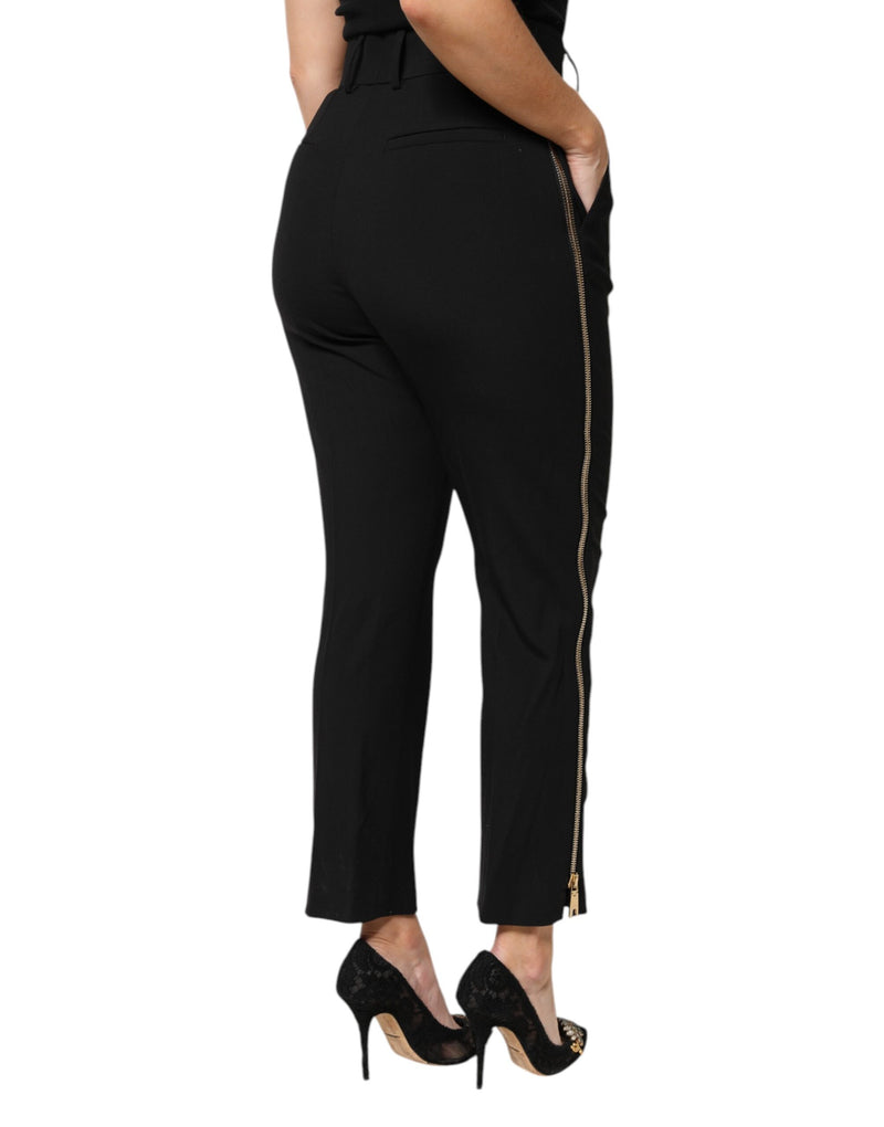 Black high-waist wool tapered pants with a long gold side zipper worn with black heels
