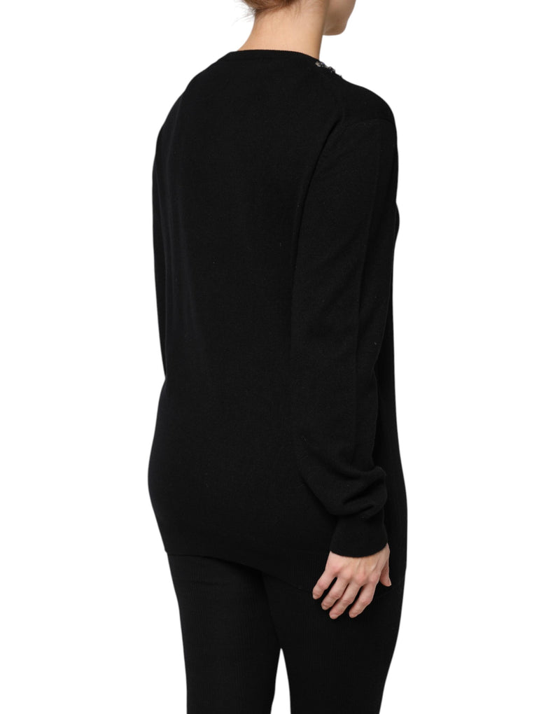 Back view of a person wearing a black cashmere crewneck sweater with crystal embellishments on the shoulder