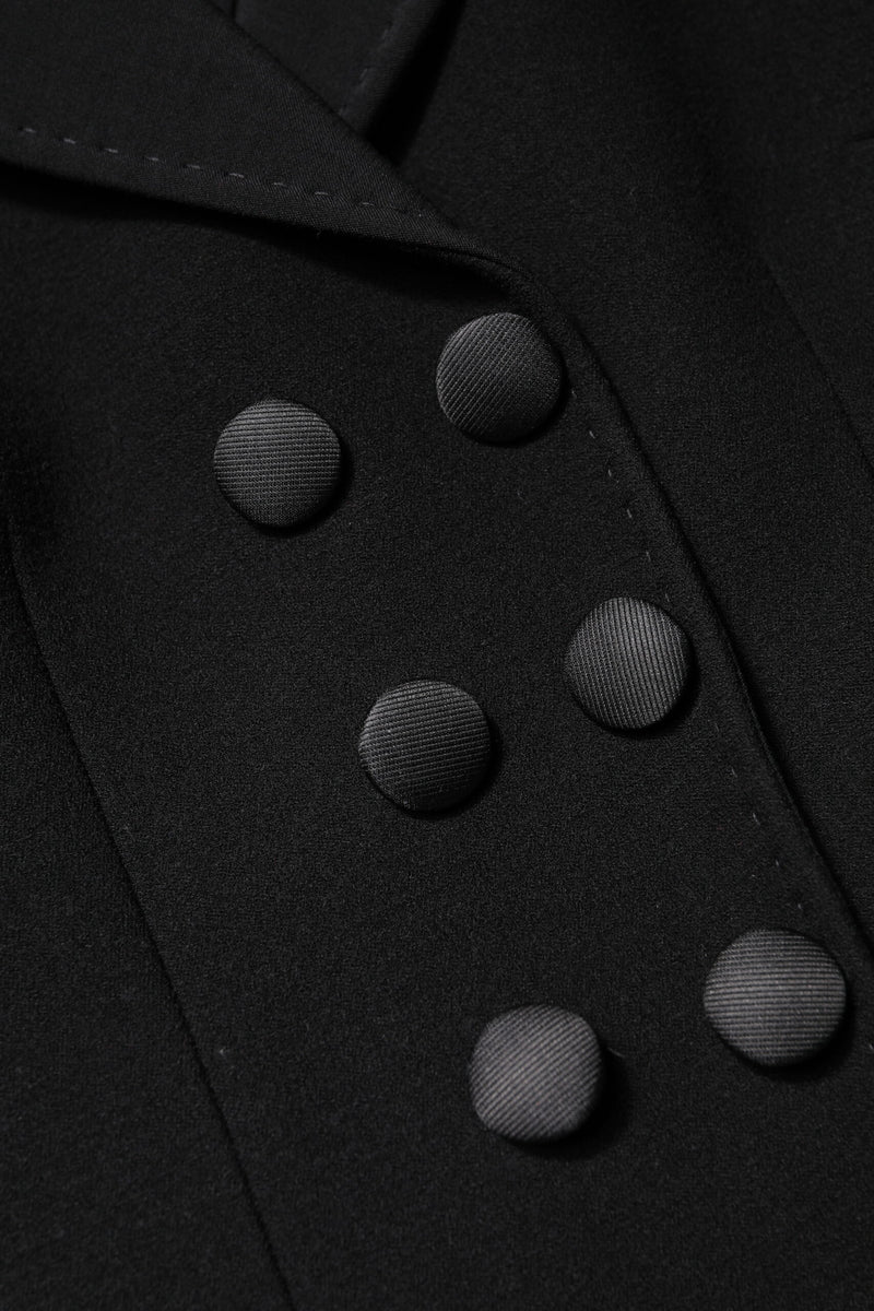 Close up of black wool double-breasted jacket featuring satin-covered buttons and lapel stitching