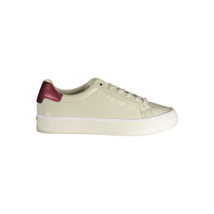 Beige leather Calvin Klein women’s sneaker with a thick white platform sole and metallic pink heel detail.