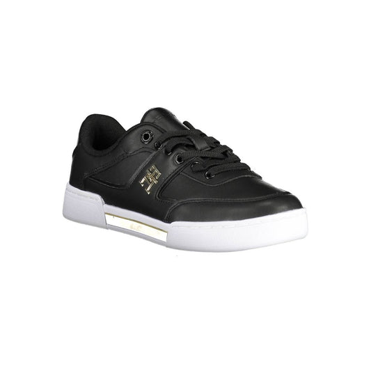 Tommy Hilfiger black polyester women’s sneaker with gold side logo, lace-up front, and chunky white rubber sole.