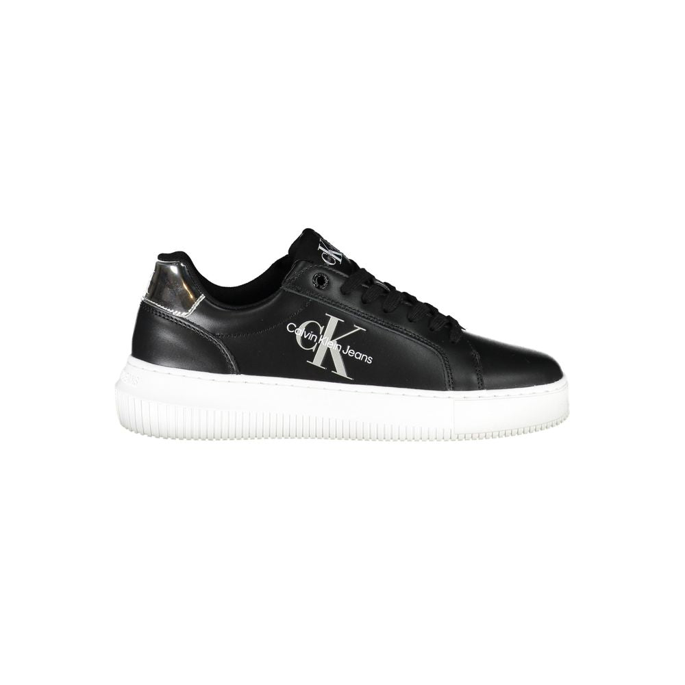 Calvin Klein black leather women’s sneaker with white logo, laces, and sole, plus a metallic silver heel accent.