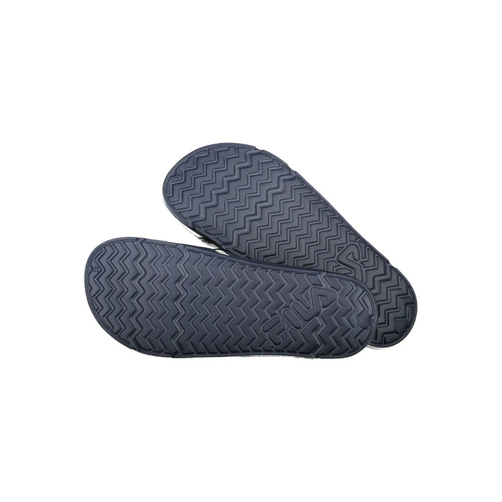 Pair of blue Fila women’s polyurethane slippers, showing the chevron-patterned non-slip outer soles.