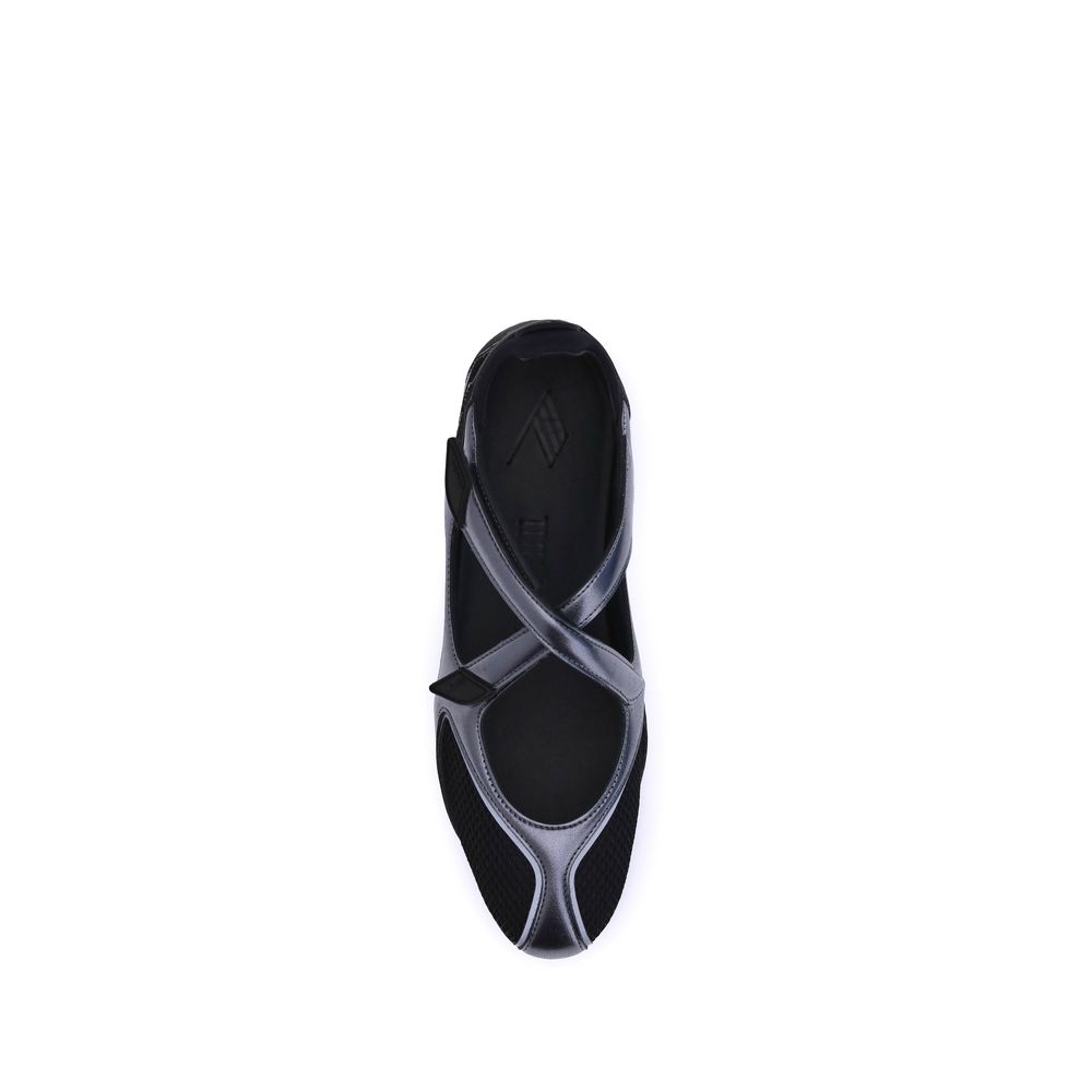Top-down view of a modern black ballet sneaker with mesh paneling, metallic trim, and a secure strap closure.