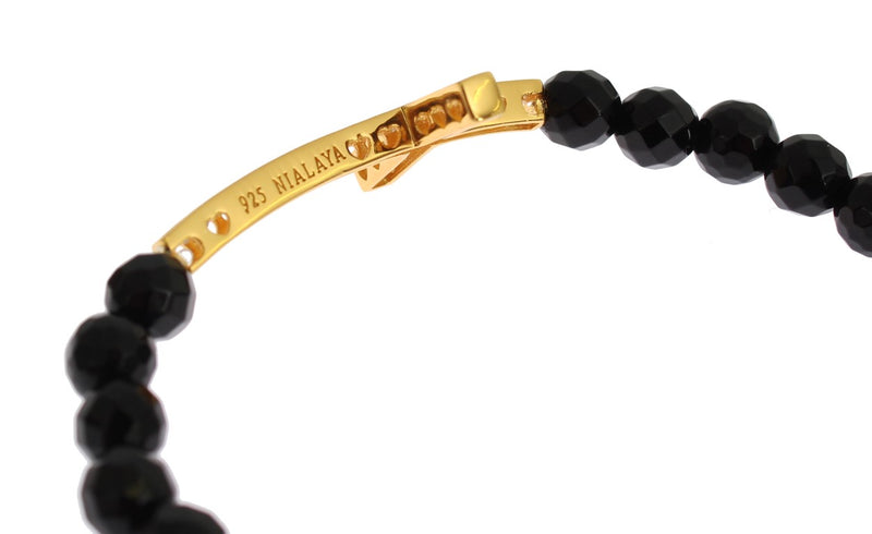 Black beaded bracelet with a gold-plated silver cross charm stamped with 925 Nialaya