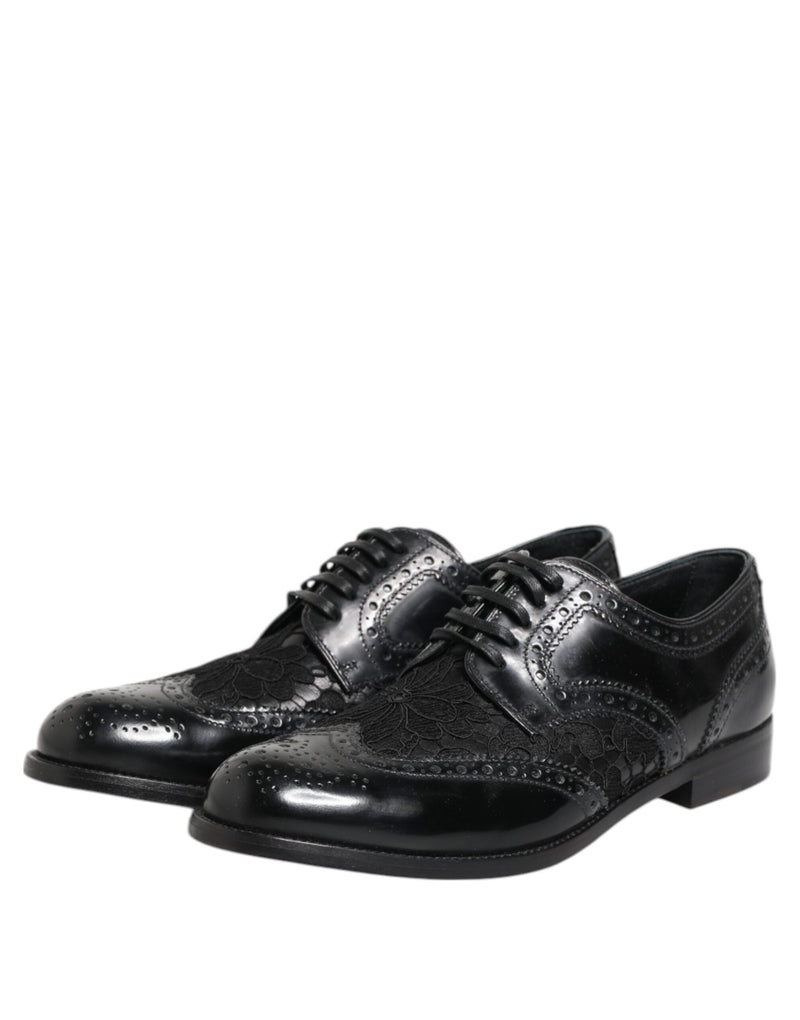 Black leather Dolce & Gabbana lace-up dress shoes with wingtip brogue detailing and floral lace overlay inserts.
