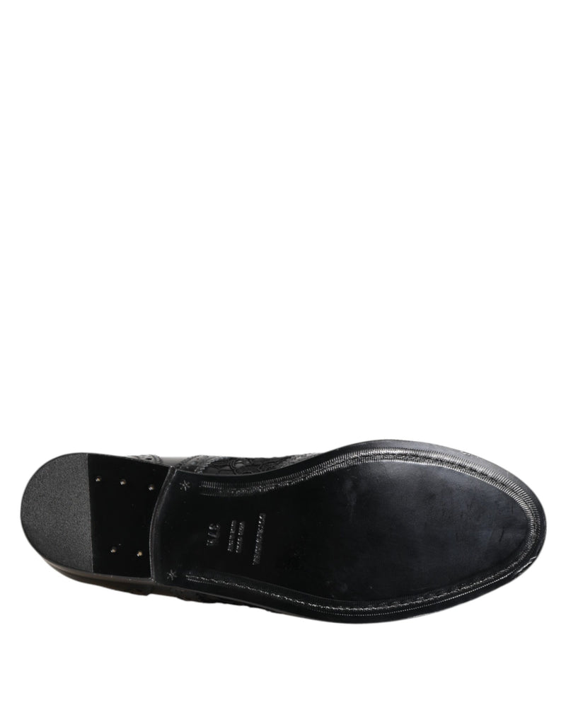 Bottom view of a black Dolce & Gabbana formal shoe featuring a smooth leather sole and lace-textured side detailing.
