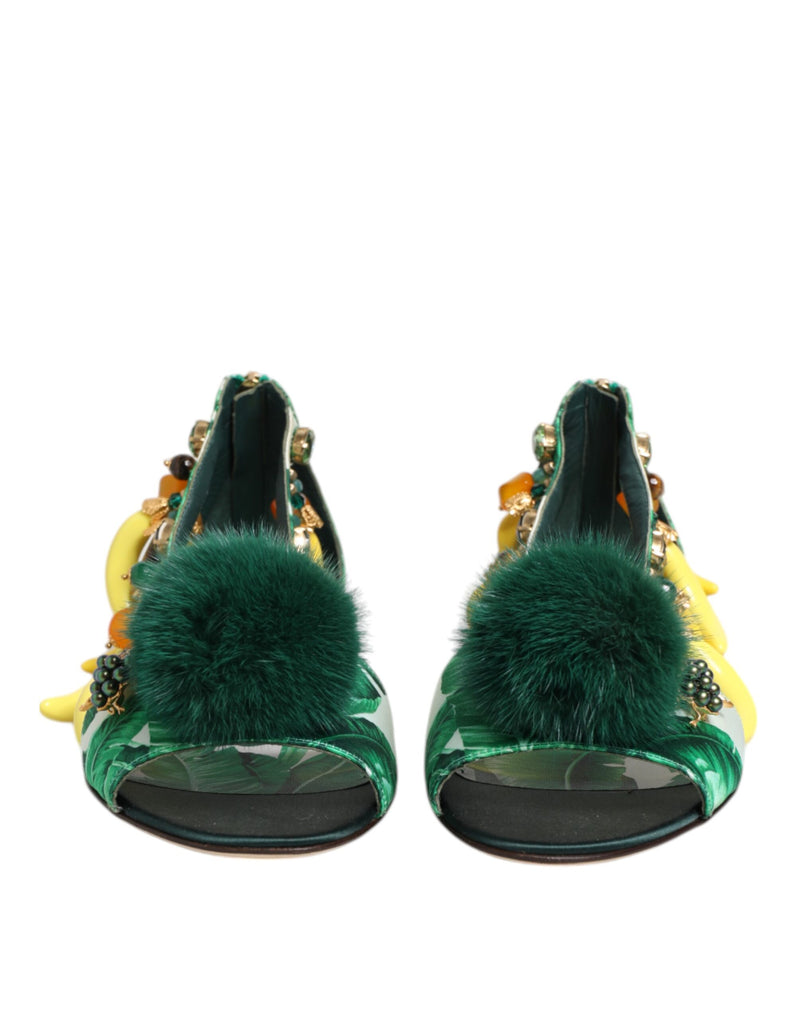 Green high-heeled shoes with fur pom-poms on a white background