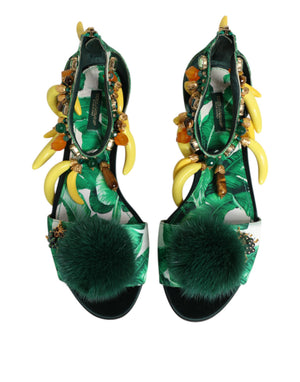 Green high-heeled shoes with decorative elements on a white background
