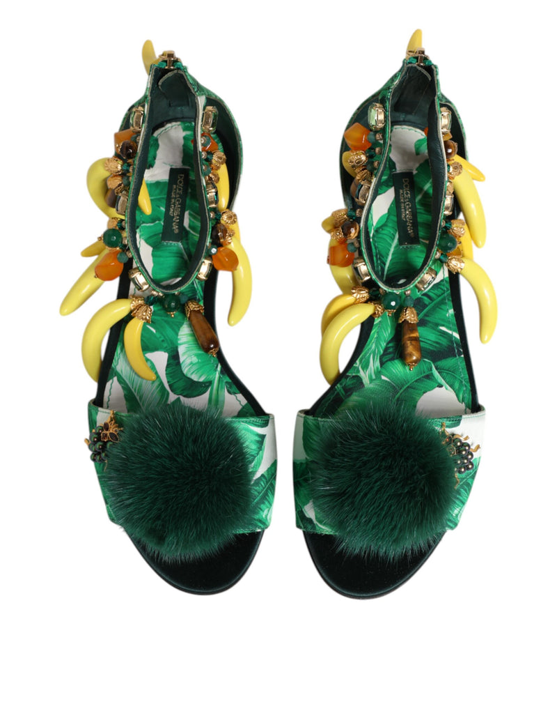 Green high-heeled shoes with decorative elements on a white background