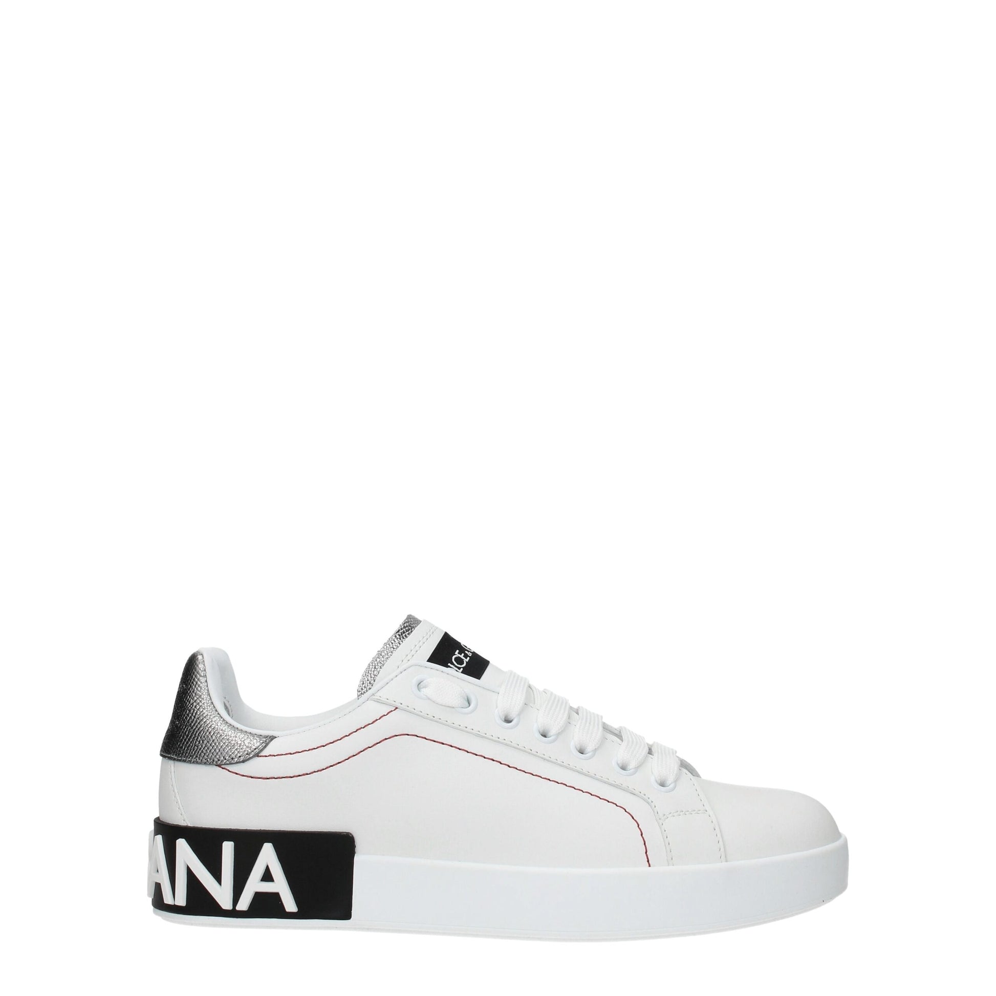 Female model wearing Dolce & Gabbana white leather low top sneakers with a clean white leather upper, signature branded detailing, and sleek low-profile sole, captured mid-step in a casual lifestyle pose showcasing the shoe's refined silhouette and luxury craftsmanship.